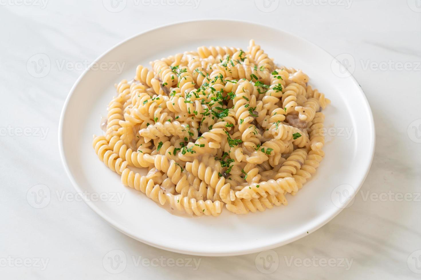 Spirali or spiral pasta mushroom cream sauce with parsley - Italian food style photo