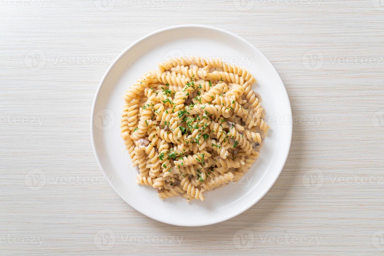 Spirali o salsa de crema de champiñones de pasta con perejil - estilo de comida italiana foto