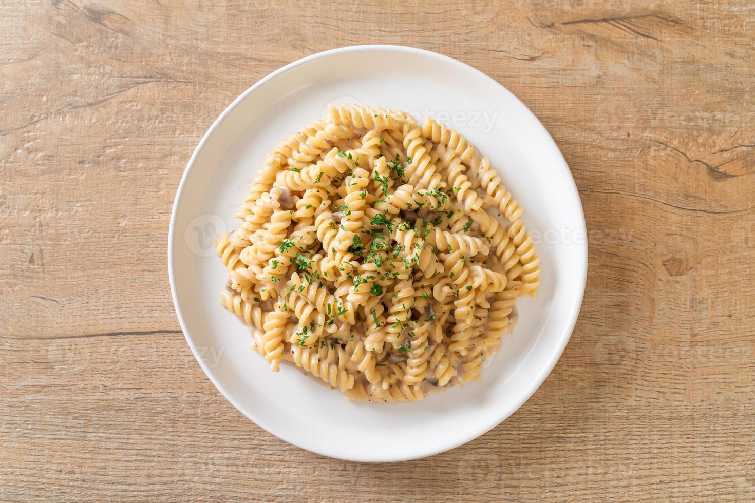 Spirali o salsa de crema de champiñones de pasta con perejil - estilo de comida italiana foto