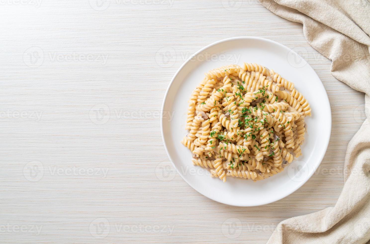Spirali or spiral pasta mushroom cream sauce with parsley - Italian food style photo