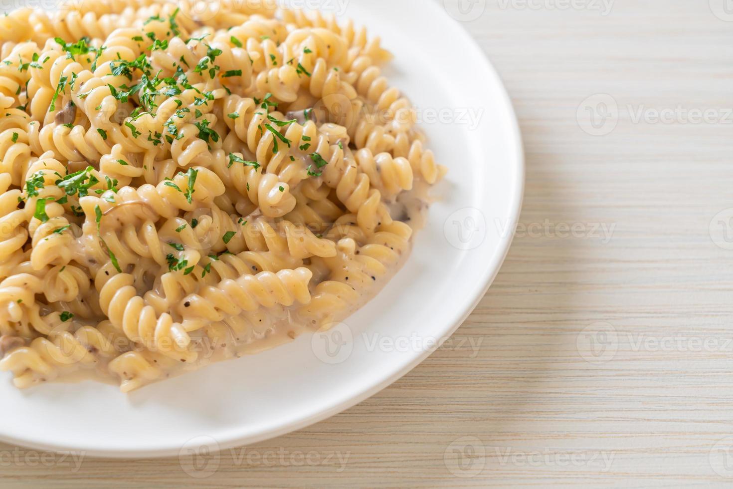 Spirali o salsa de crema de champiñones de pasta con perejil - estilo de comida italiana foto