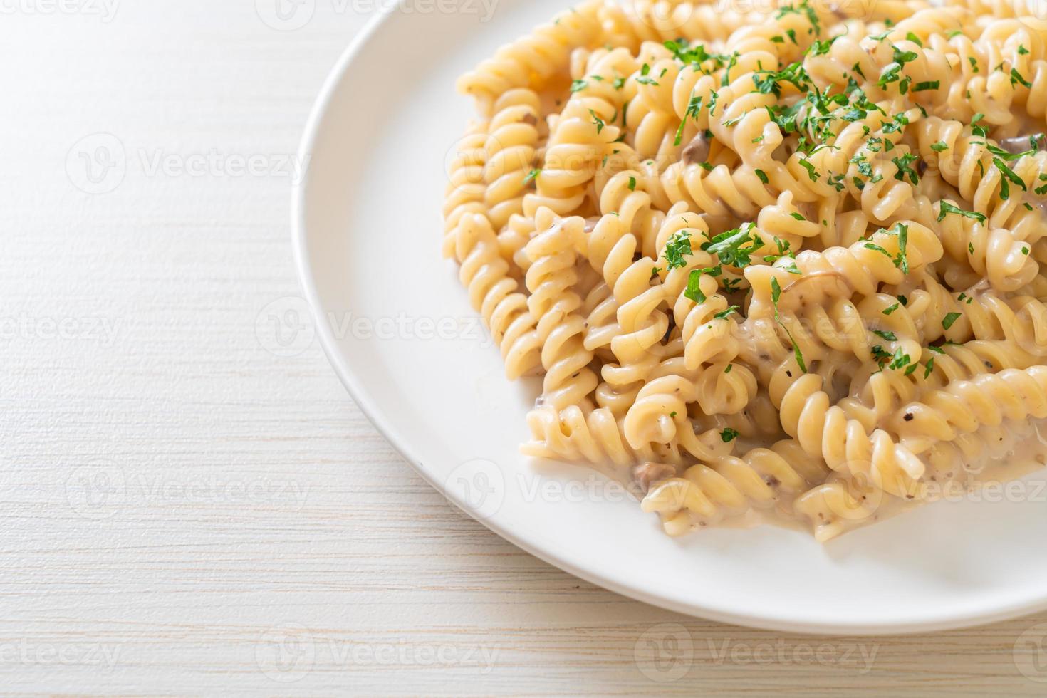 Spirali or spiral pasta mushroom cream sauce with parsley - Italian food style photo