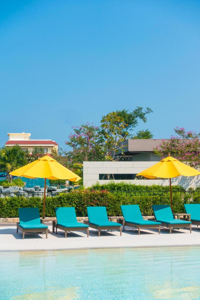 Umbrella and chair around swimming pool photo