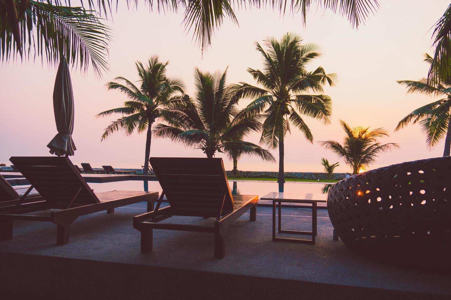 Silhouette coconut palm tree around outdoor swimming pool photo