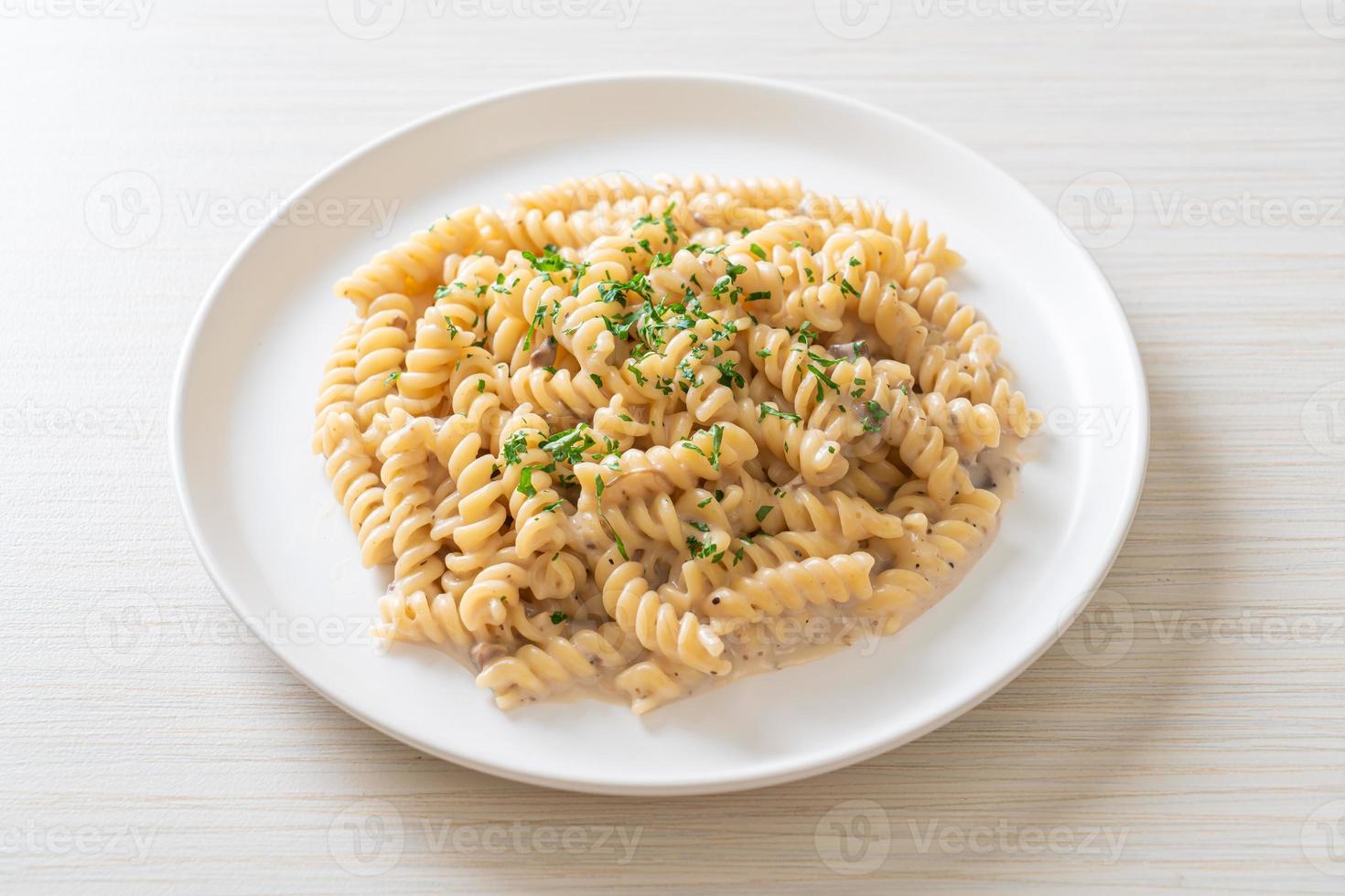 Spirali or spiral pasta mushroom cream sauce with parsley - Italian food style photo