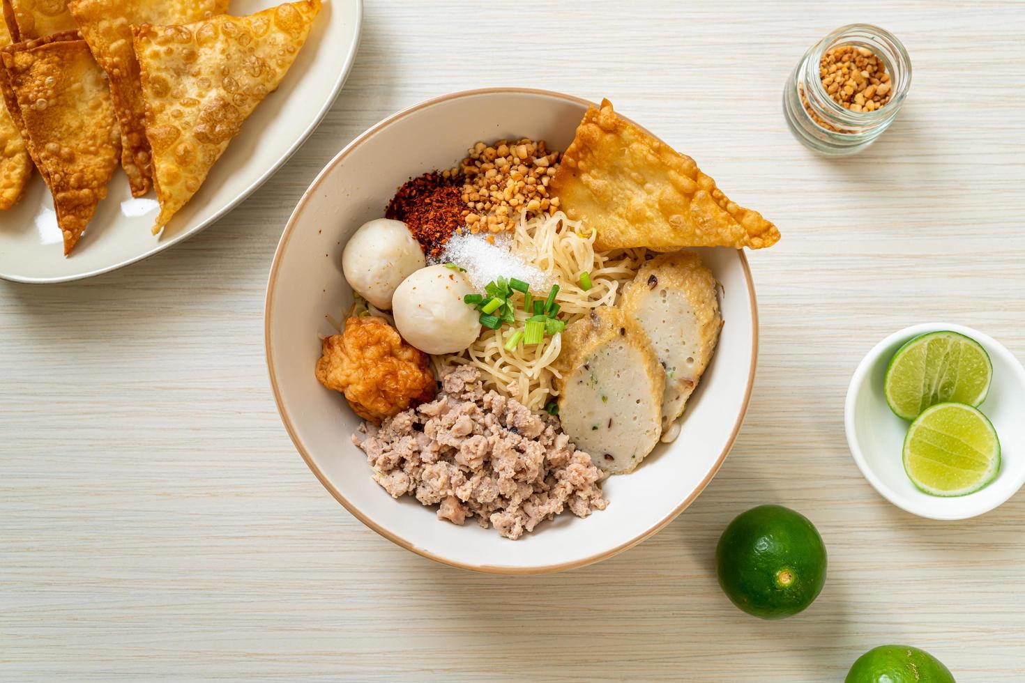 Fideos de huevo picantes con bolas de pescado y bolas de camarones sin sopa - estilo de comida asiática foto