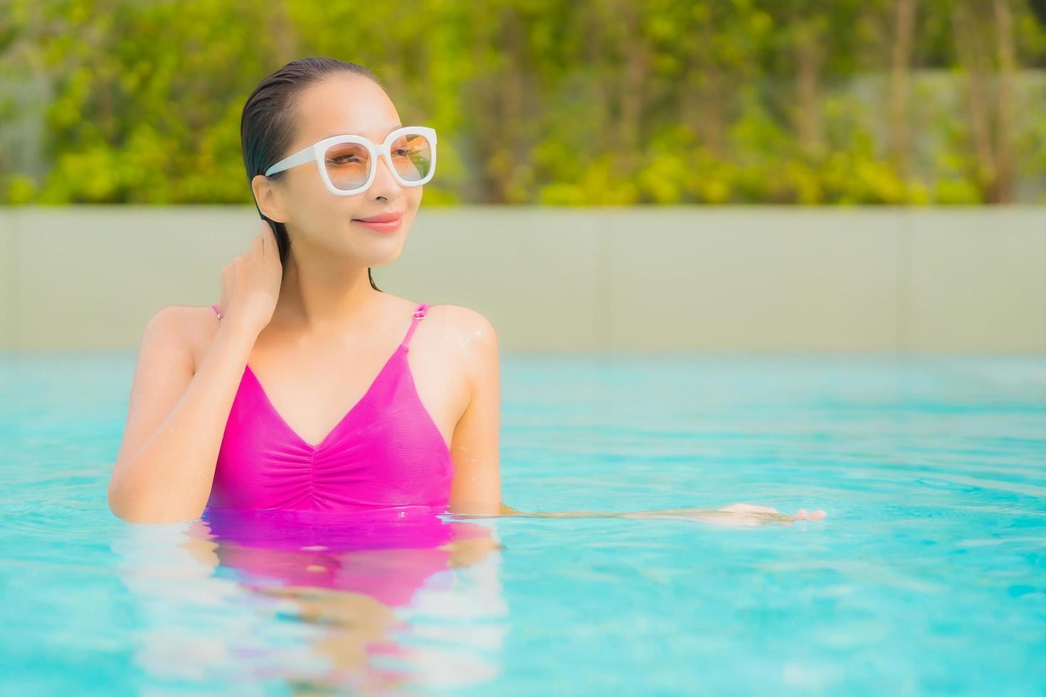 retrato, hermoso, joven, mujer asiática, relajarse, sonrisa, alrededor, piscina al aire libre, en, hotel, resort foto