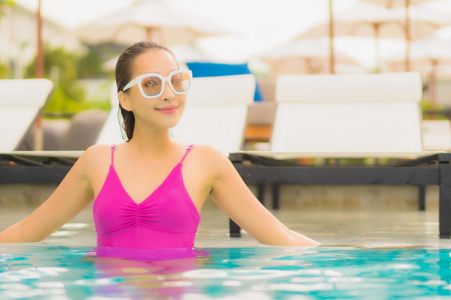 retrato, hermoso, joven, mujer asiática, relajarse, sonrisa, alrededor, piscina al aire libre, en, hotel, resort foto