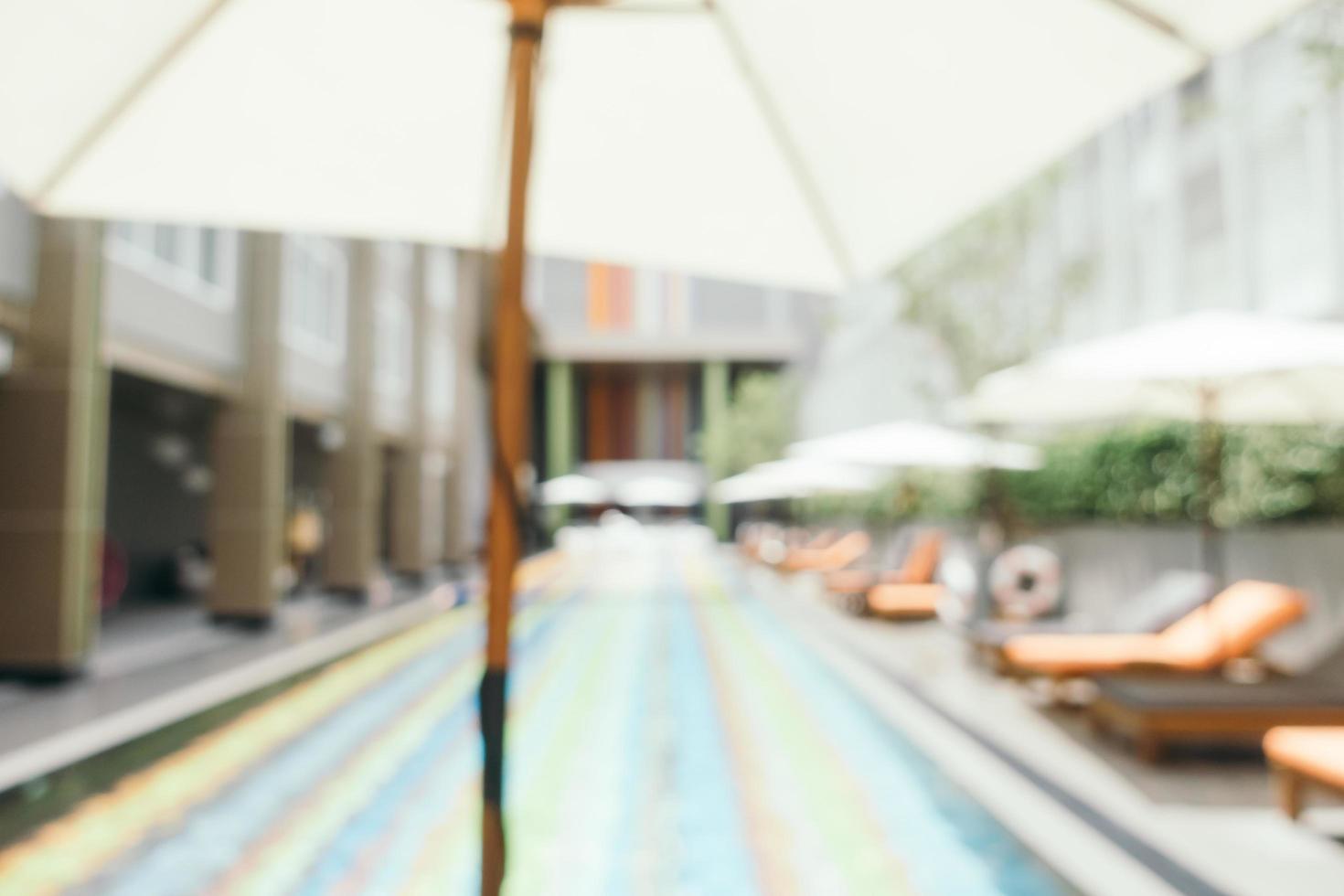 Abstract blur and defocused umbrella and chair around swimming pool photo