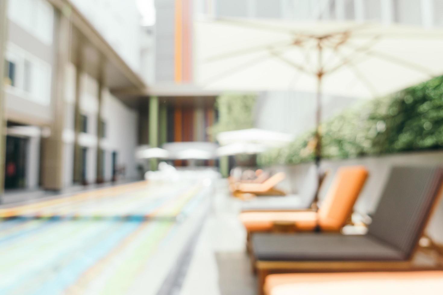 Abstract blur and defocused umbrella and chair around swimming pool photo