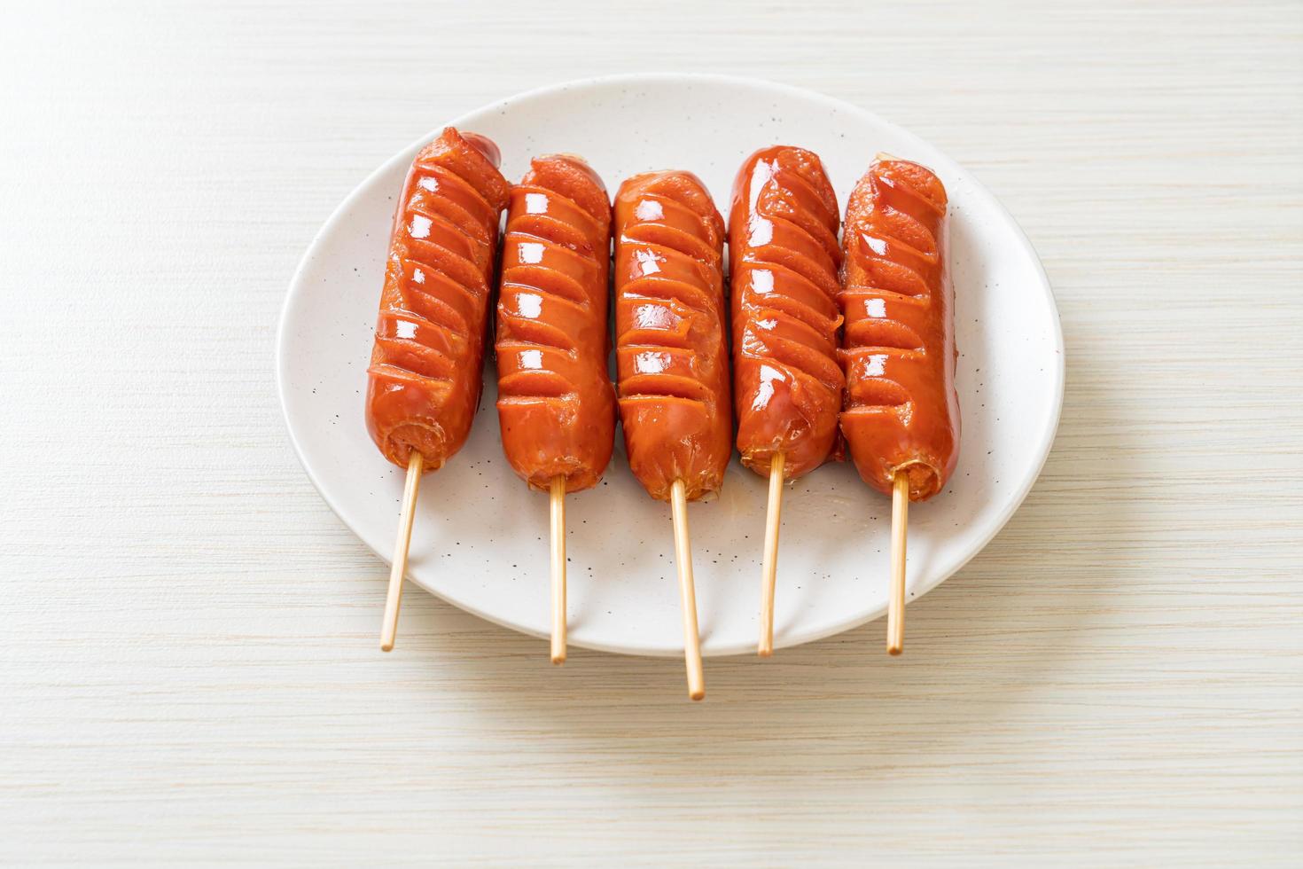 Fried sausage skewer on white plate photo