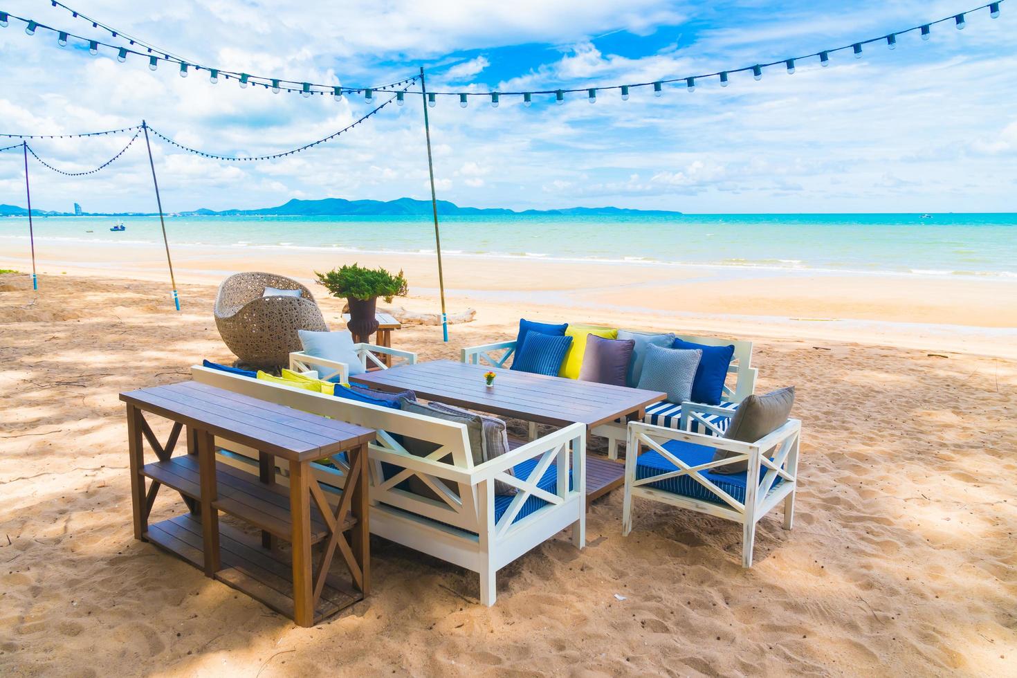 Chair and table dinning on the beach and sea with blue sky photo