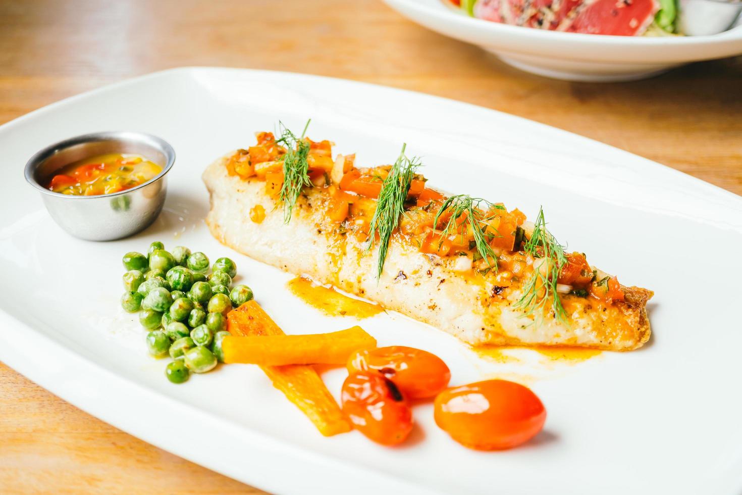 Carne de pescado de lubina a la plancha con salsa foto