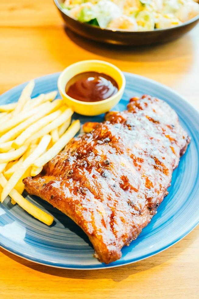 BBQ a la parrilla o costilla a la barbacoa con papas fritas foto