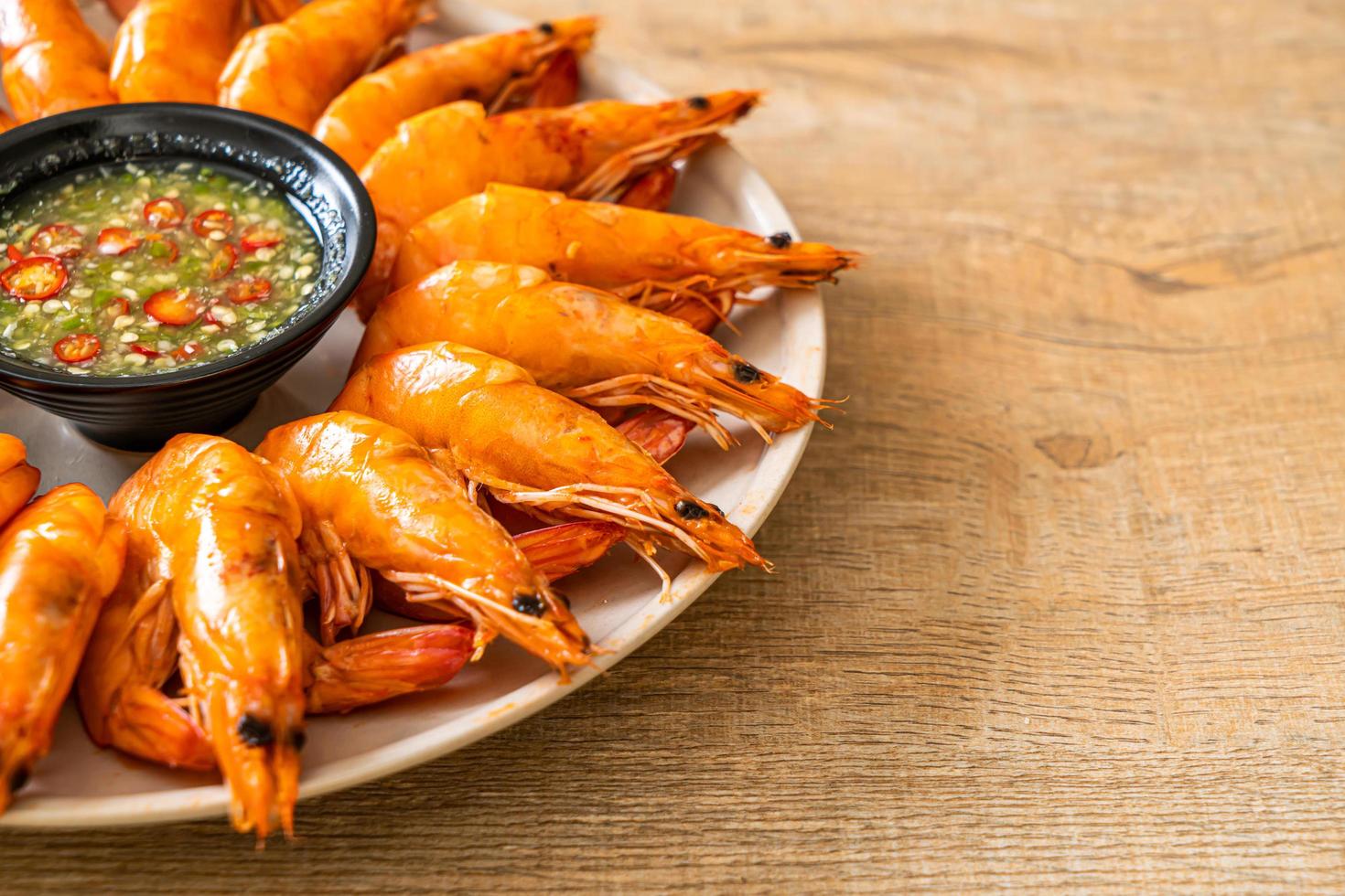 Baked salted shrimps or prawns with seafood spicy sauce - seafood style photo