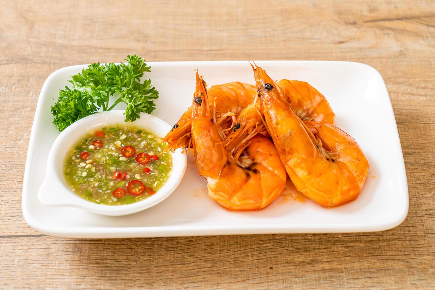 Baked salted shrimps or prawns with seafood spicy sauce - seafood style photo