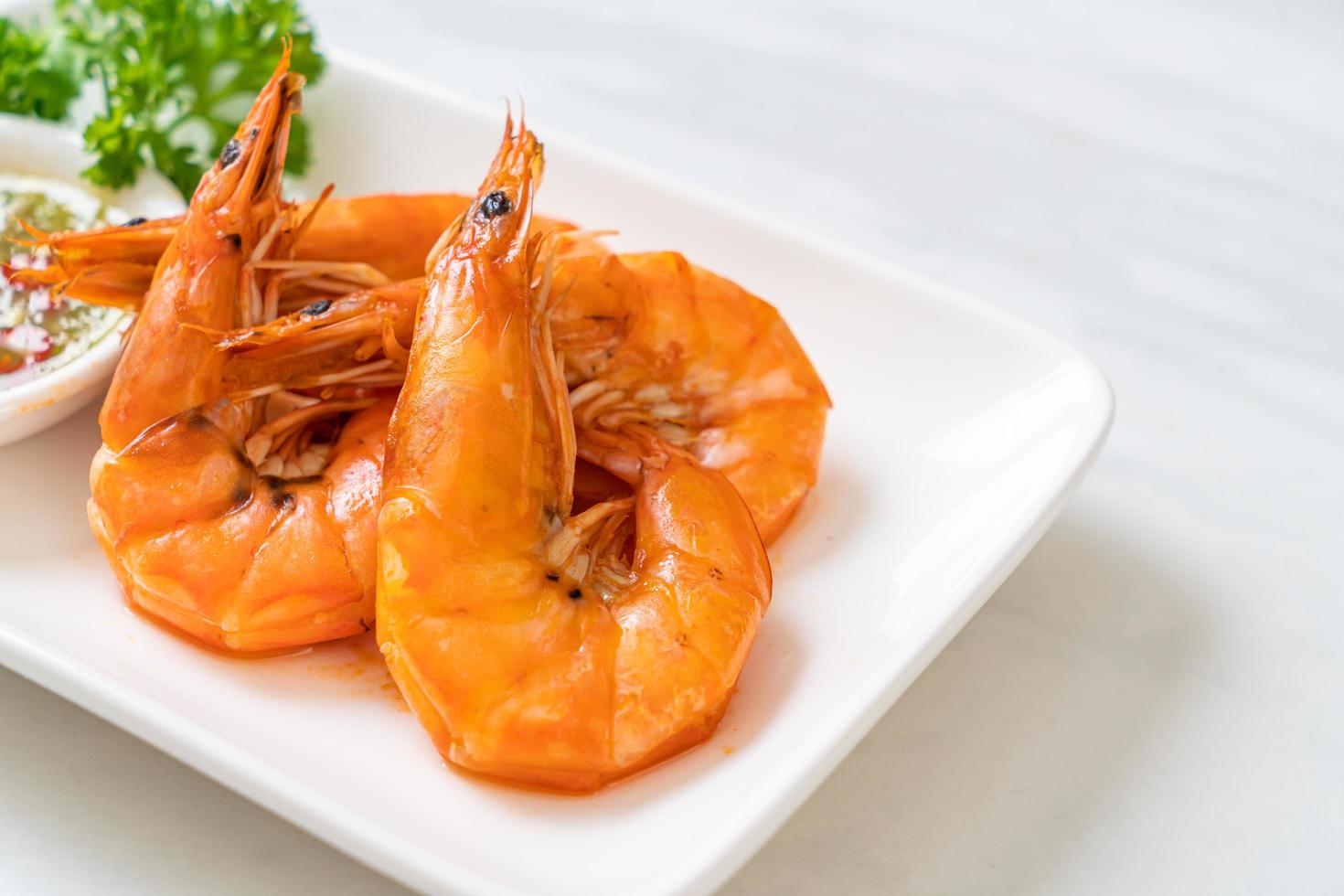 Baked salted shrimps or prawns with seafood spicy sauce - seafood style photo