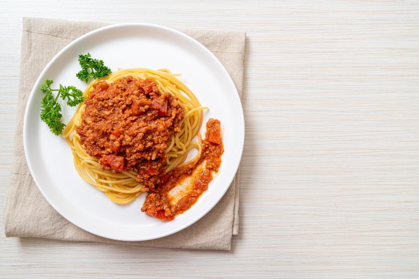 espaguetis de cerdo a la boloñesa o espaguetis con salsa de tomate de cerdo picada - estilo de comida italiana foto