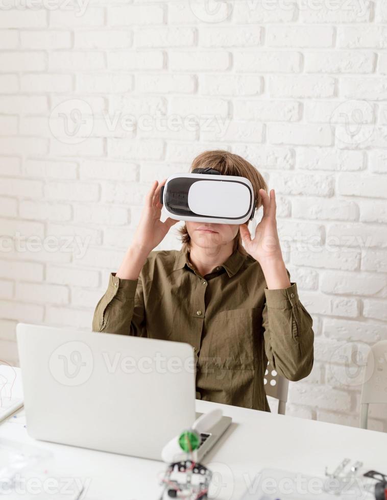 muchacho adolescente en gafas de realidad virtual jugando el juego foto