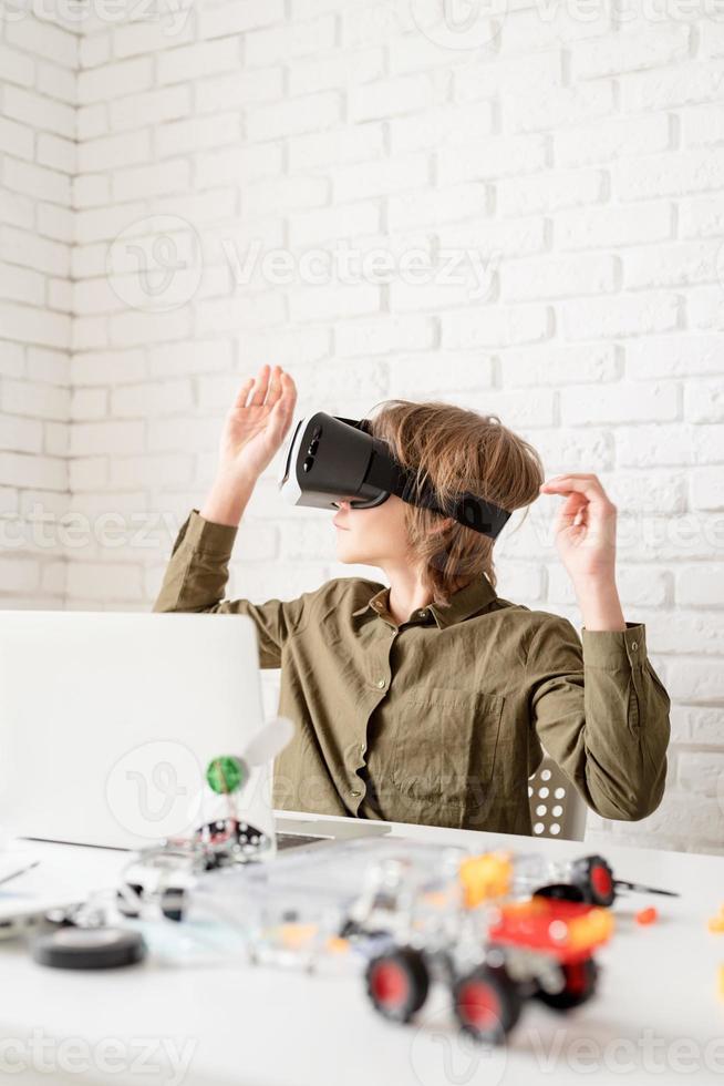 muchacho adolescente en gafas de realidad virtual jugando el juego foto