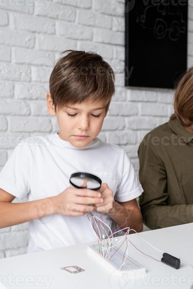 boy working with LED lights on experimental board for science project