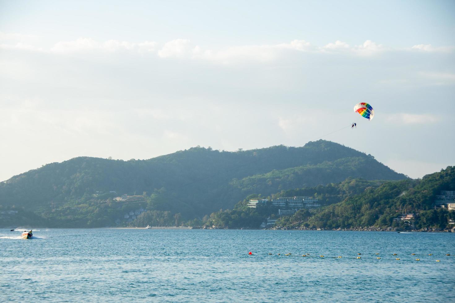 parasailing sobre el mar con un hermoso fondo de cielo azul en la playa de patong, phuket, tailandia. socus suave. foto