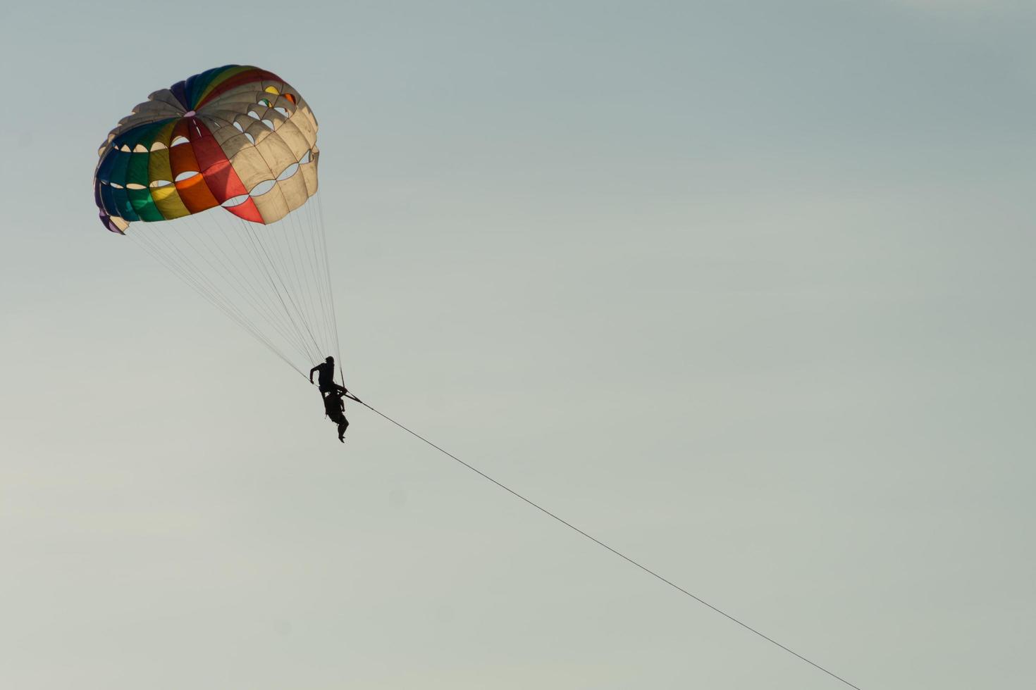 parasailing sobre el mar con un hermoso fondo de cielo azul en la playa de patong, phuket, tailandia. socus suave. foto