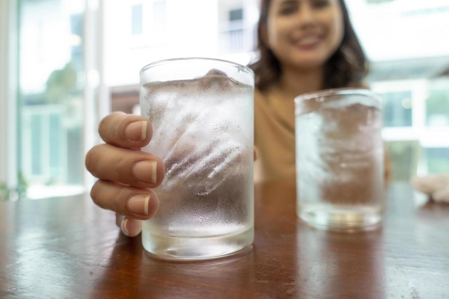 Cerca de la mano sostiene vasos de agua fría foto