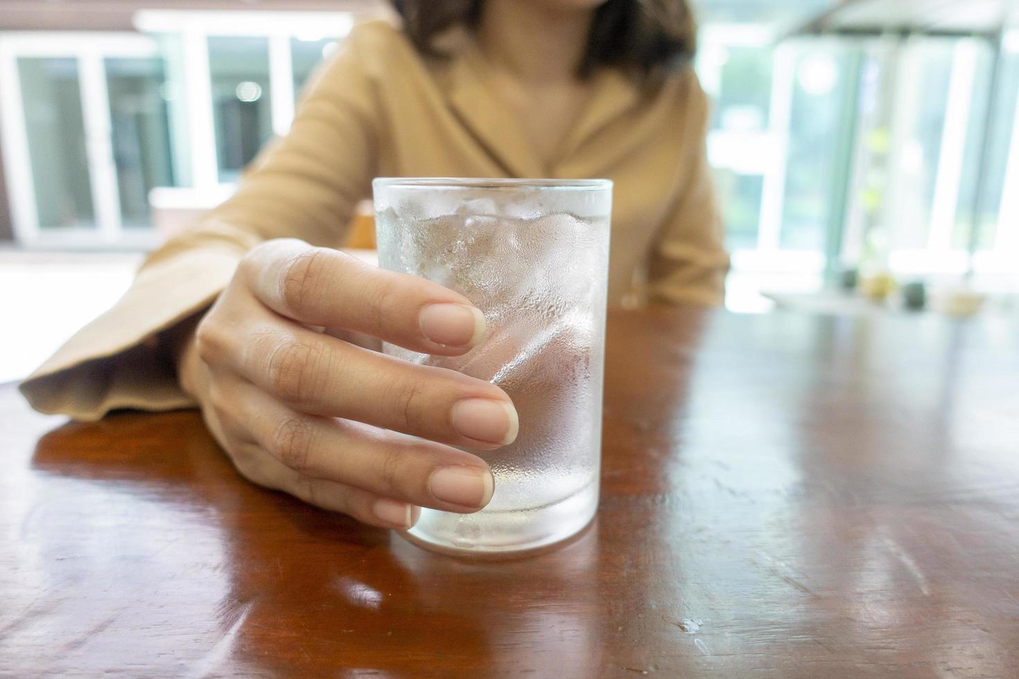 Cerca de la mano sostiene vasos de agua fría foto