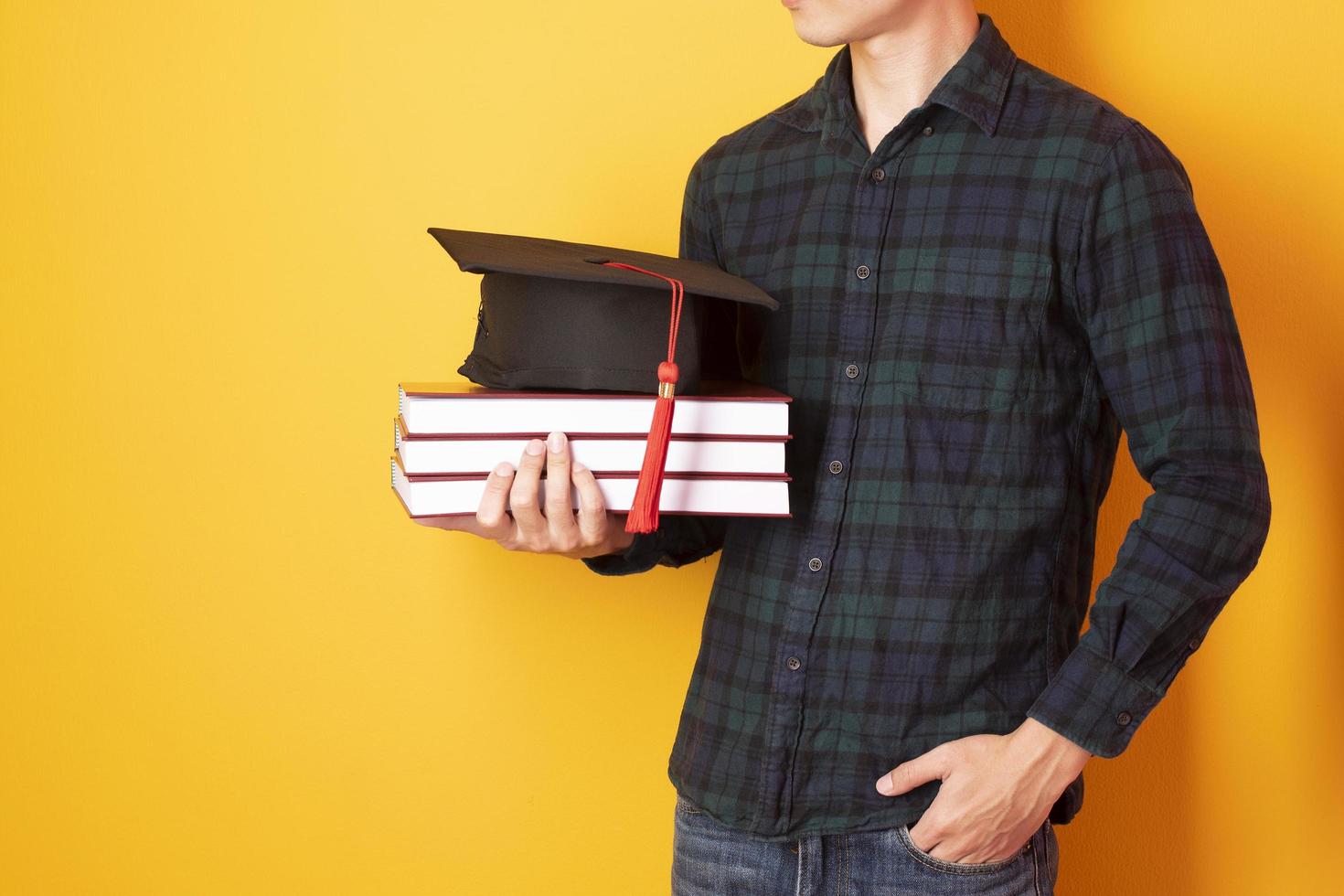 University man is happy with graduation on yellow background photo