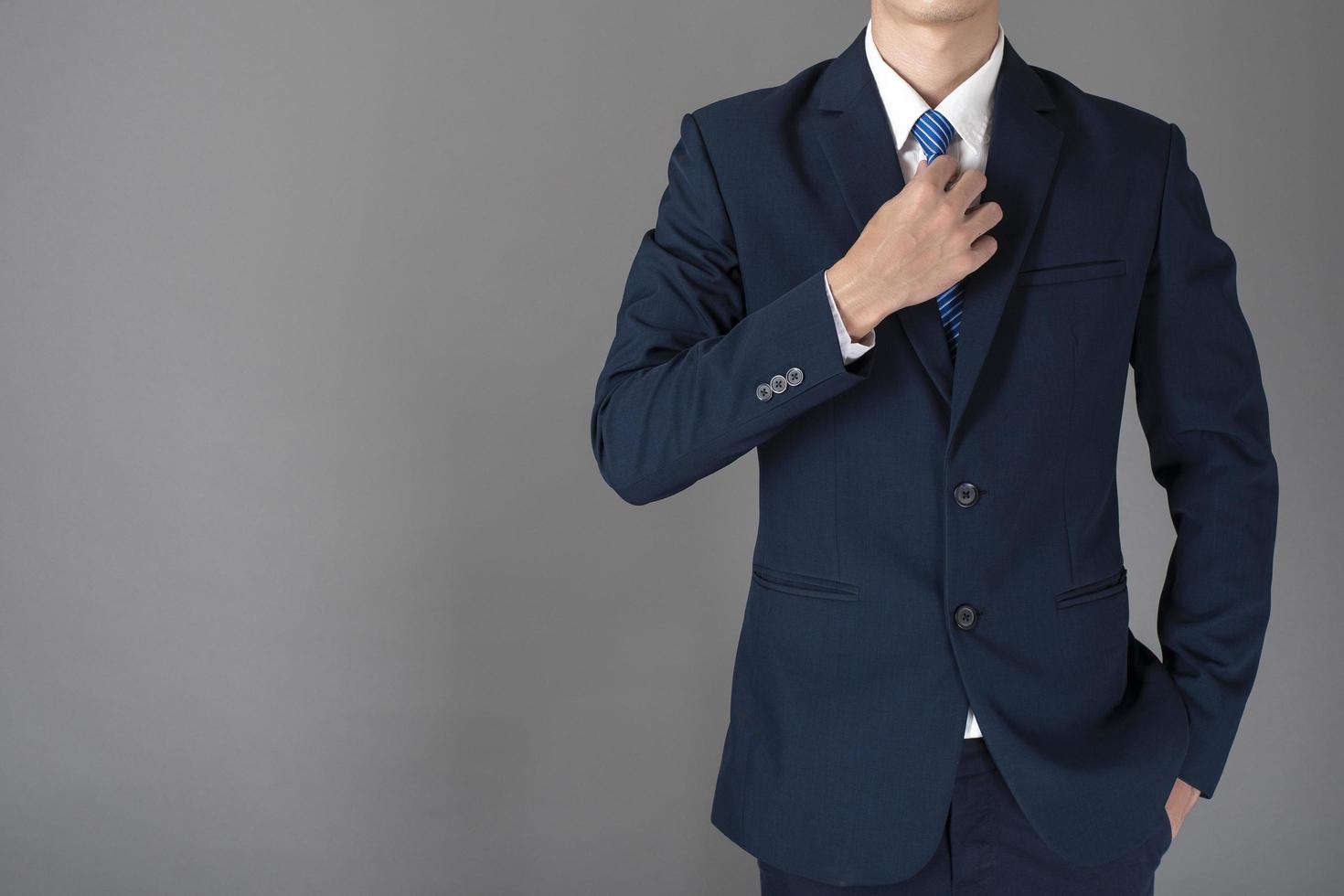 close up of business man in blue suit is confident on gray background photo