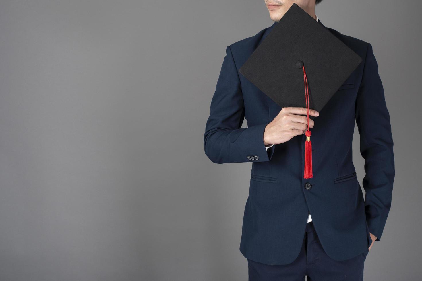 El hombre de negocios está sosteniendo un sombrero de graduación, concepto de educación empresarial foto