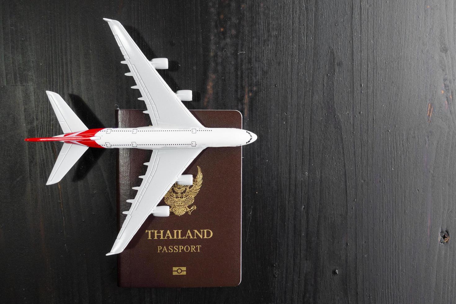 Airplane model and passport on wooden desk, ready travel concept photo