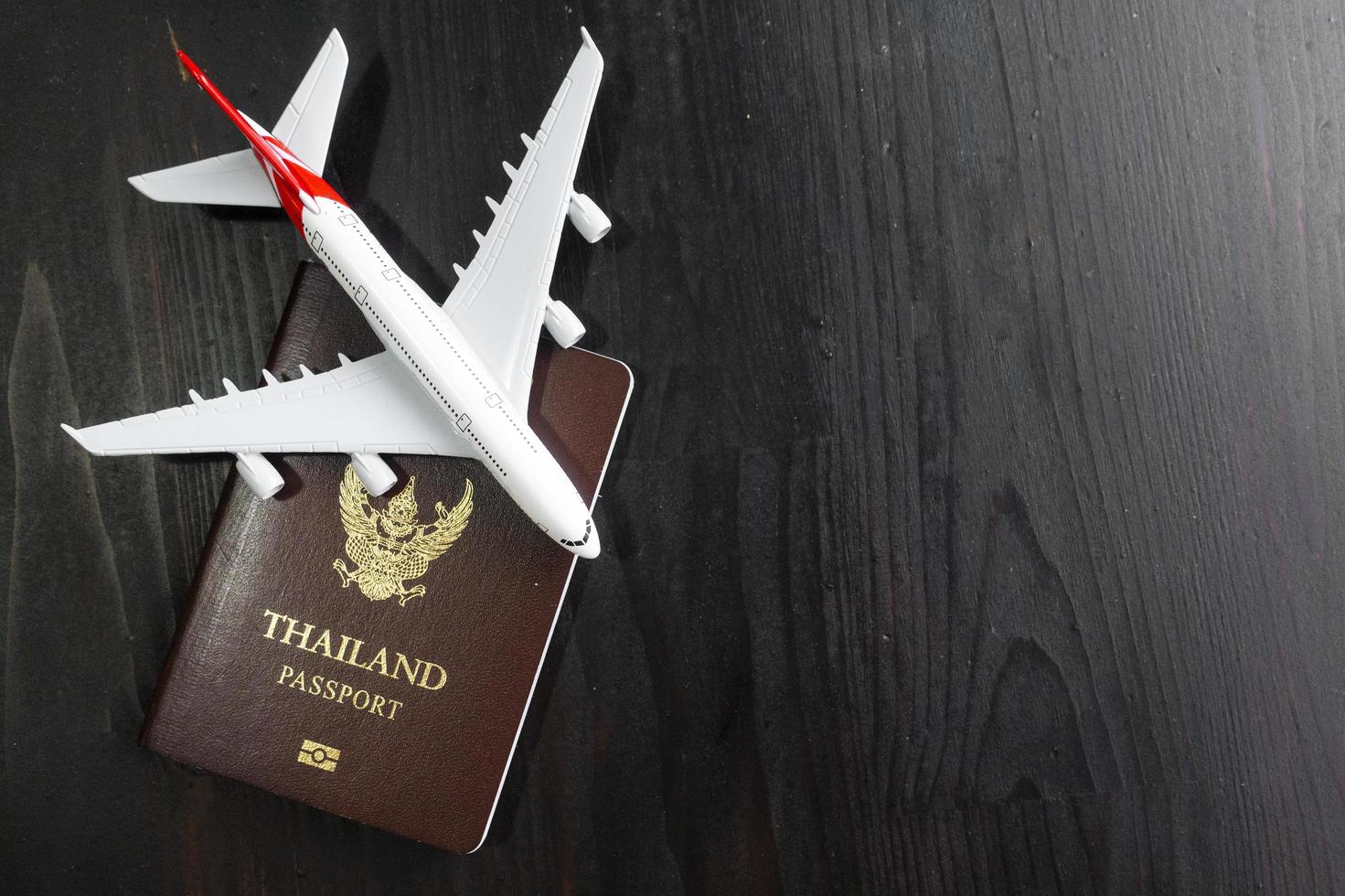Airplane model and passport on wooden desk, ready travel concept photo