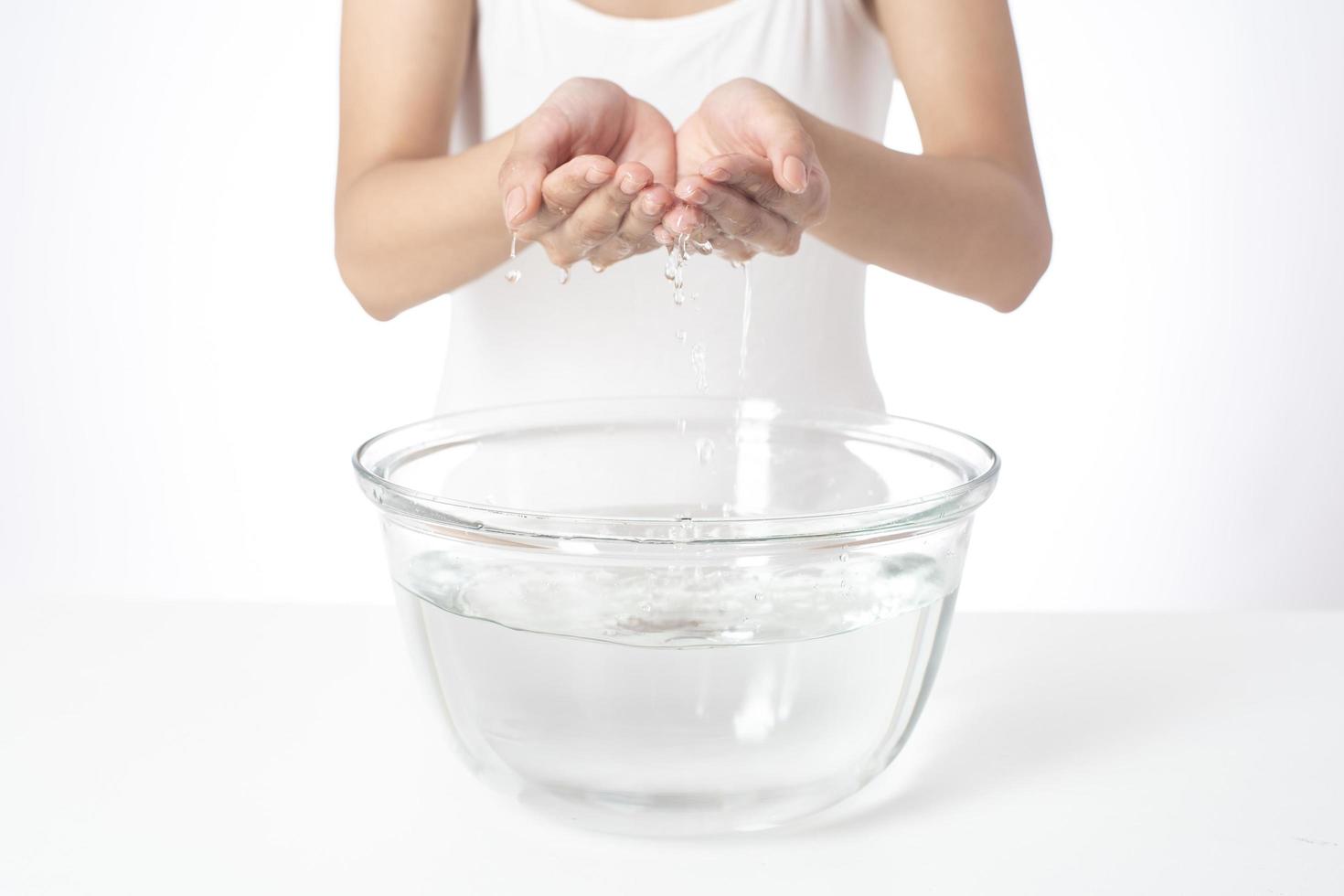 Beautiful woman is washing her face on white background photo