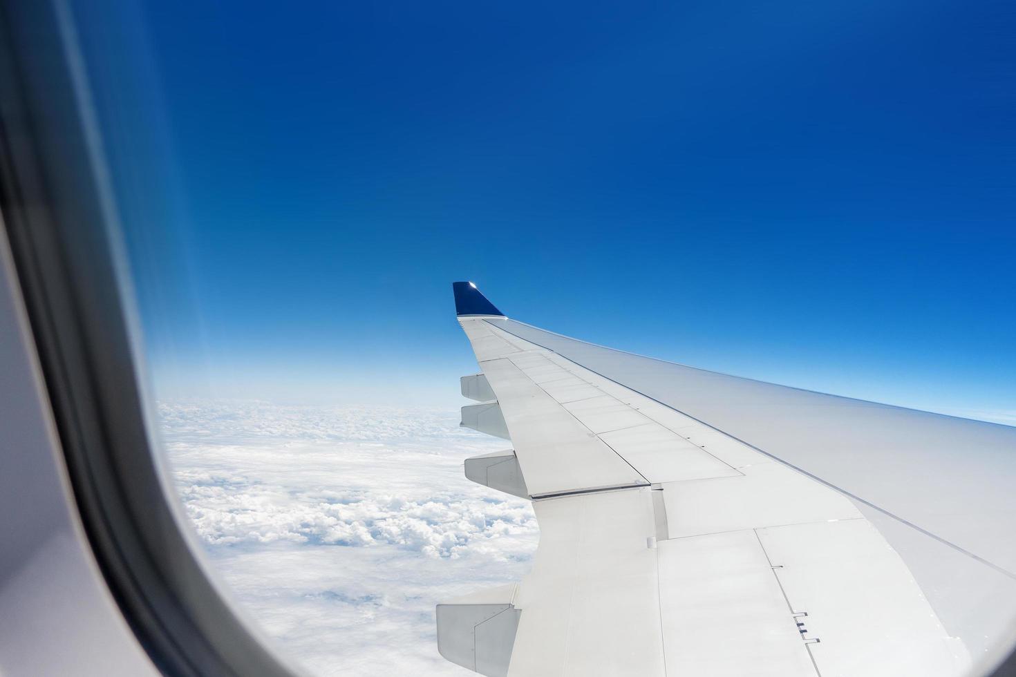 Beautiful view of cloudscape and airplane wing seen through window of an airplane photo