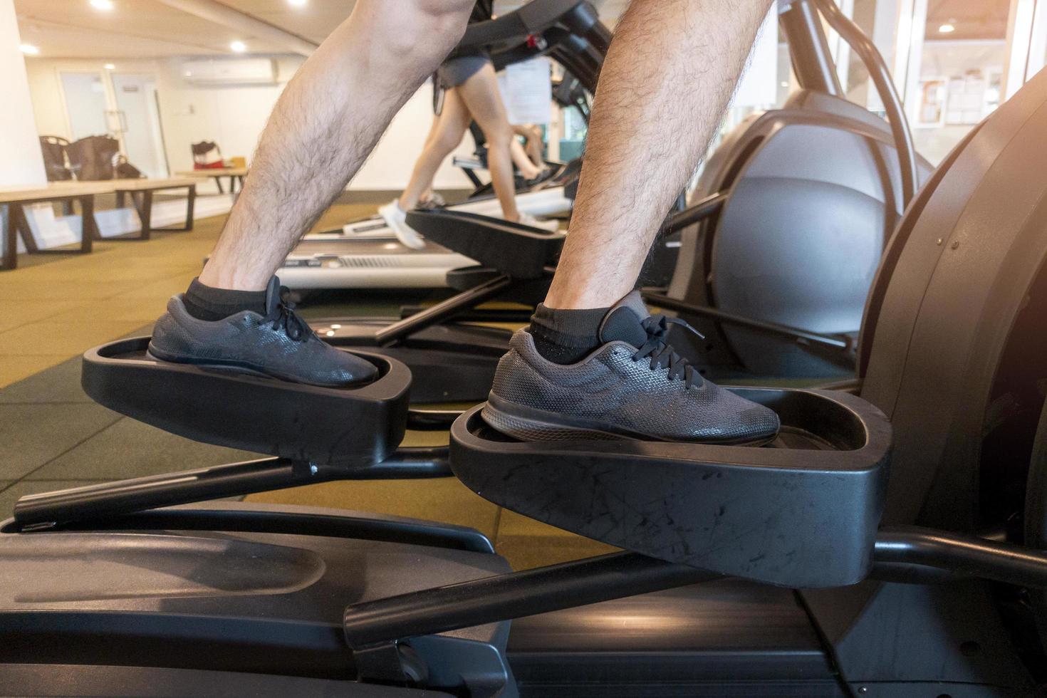 Hombre con máquina elíptica en el gimnasio. foto