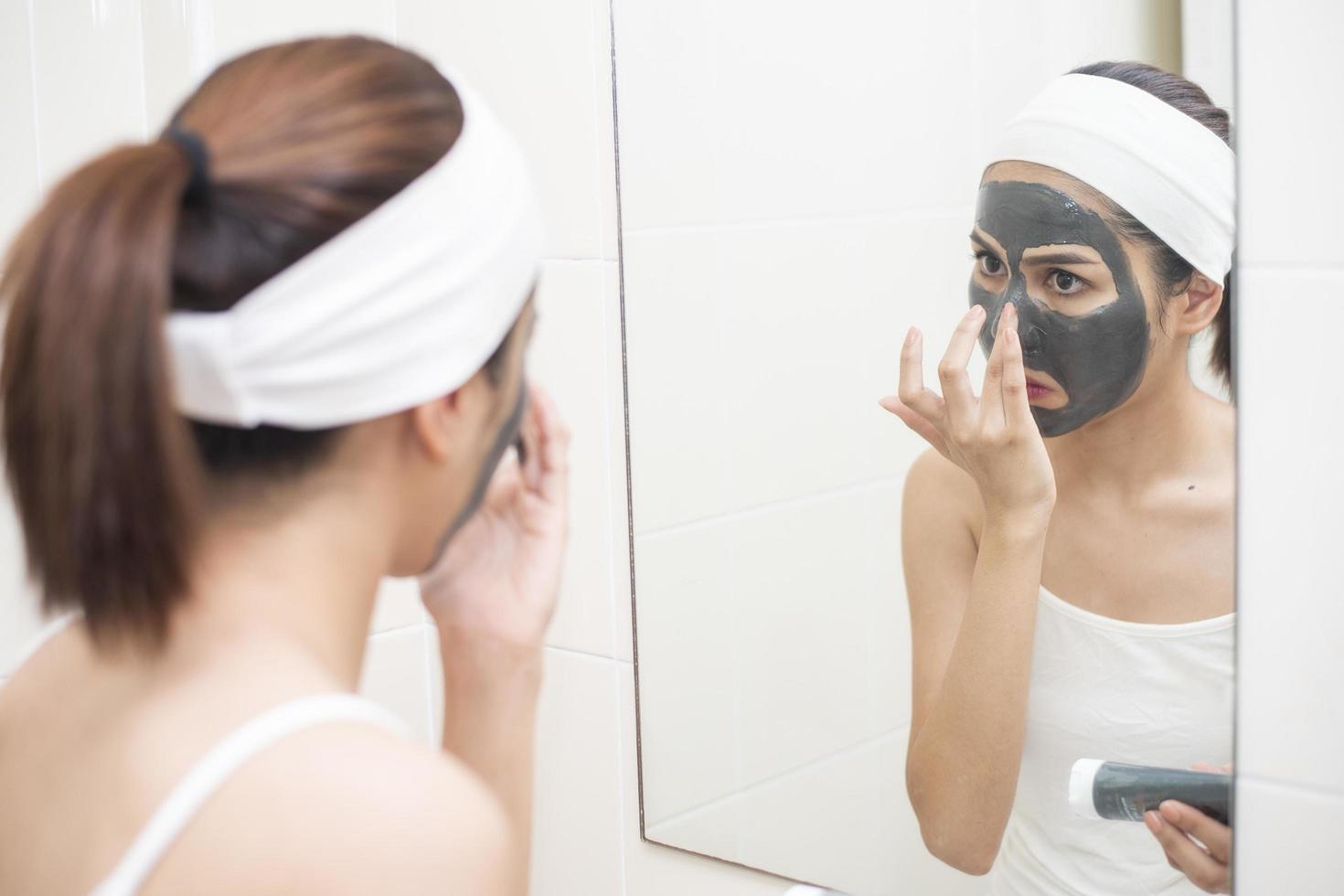 Bella mujer enmascarando su rostro sobre fondo blanco. foto