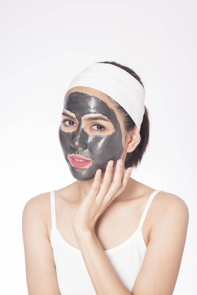 Beautiful woman masking her face on white background photo