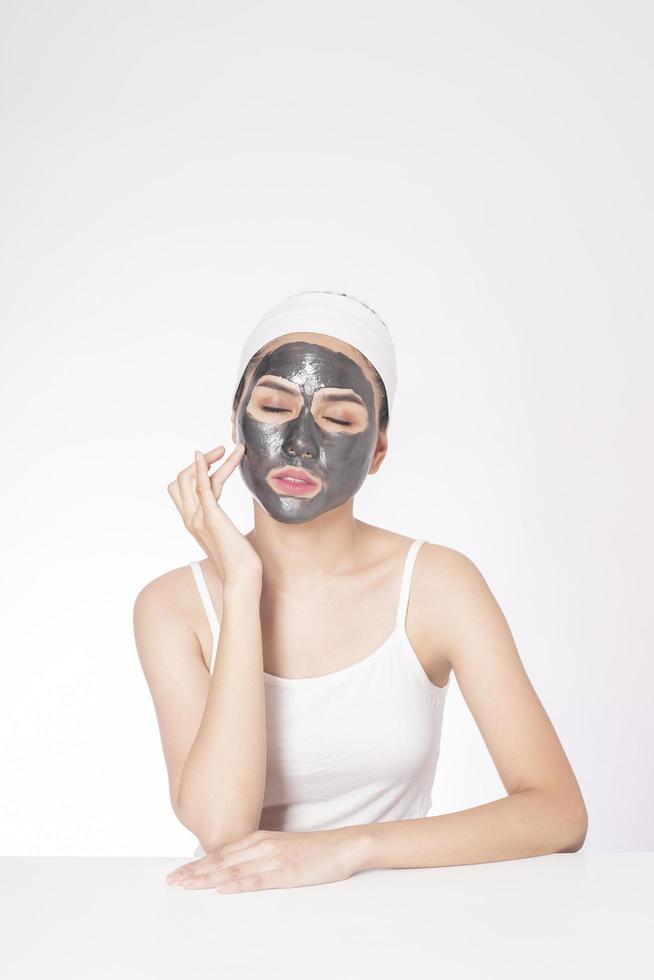 Beautiful woman masking her face on white background photo