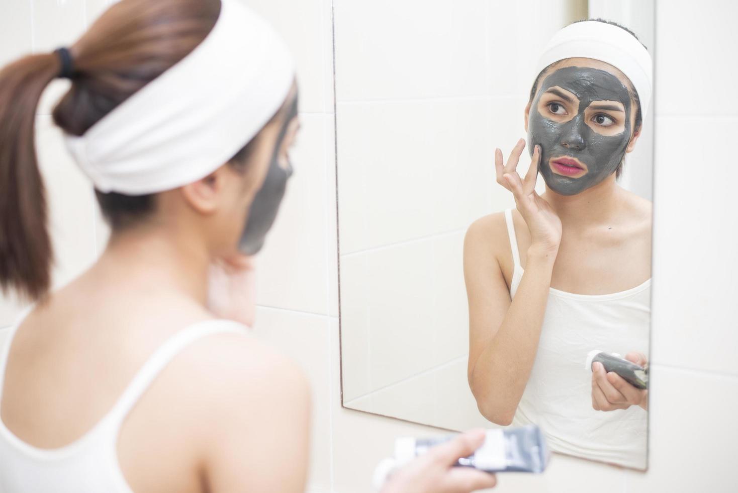 Bella mujer enmascarando su rostro sobre fondo blanco. foto