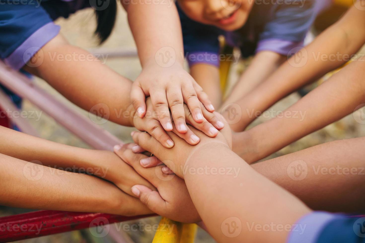 Group of diverse kids hands of together joining for teamwork, community, togetherness and collaboration concept. photo