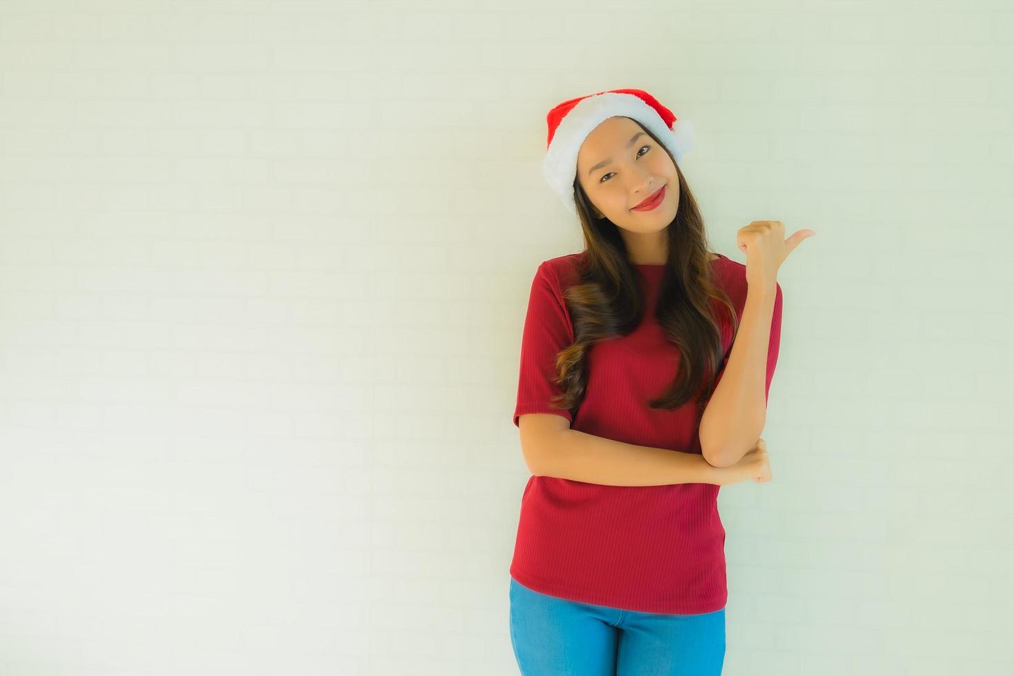 Retrato de hermosas mujeres asiáticas jóvenes vistiendo gorro de Papá Noel para la celebración de Navidad foto