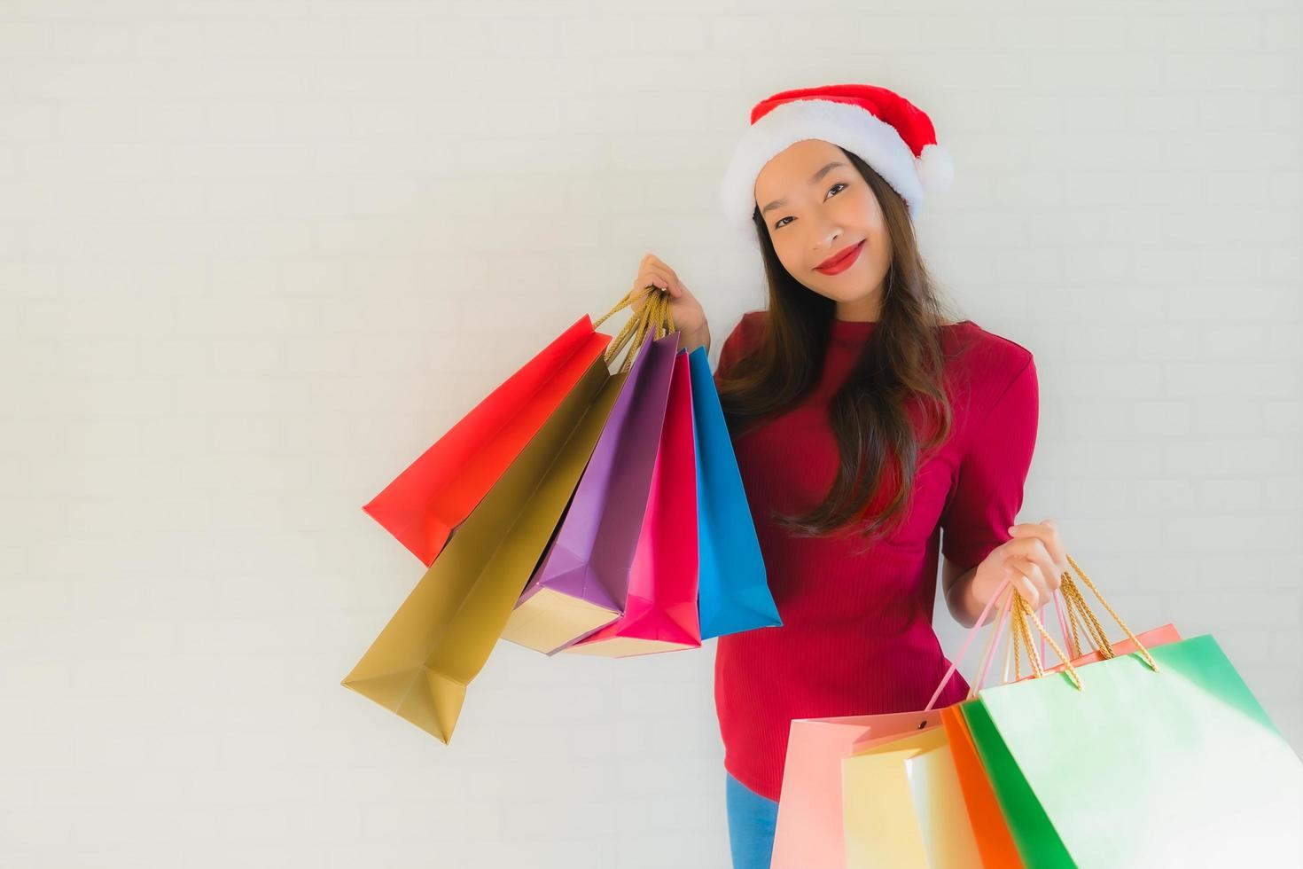 Retrato de hermosas mujeres asiáticas jóvenes usan gorro de Papá Noel de Navidad con bolsa foto