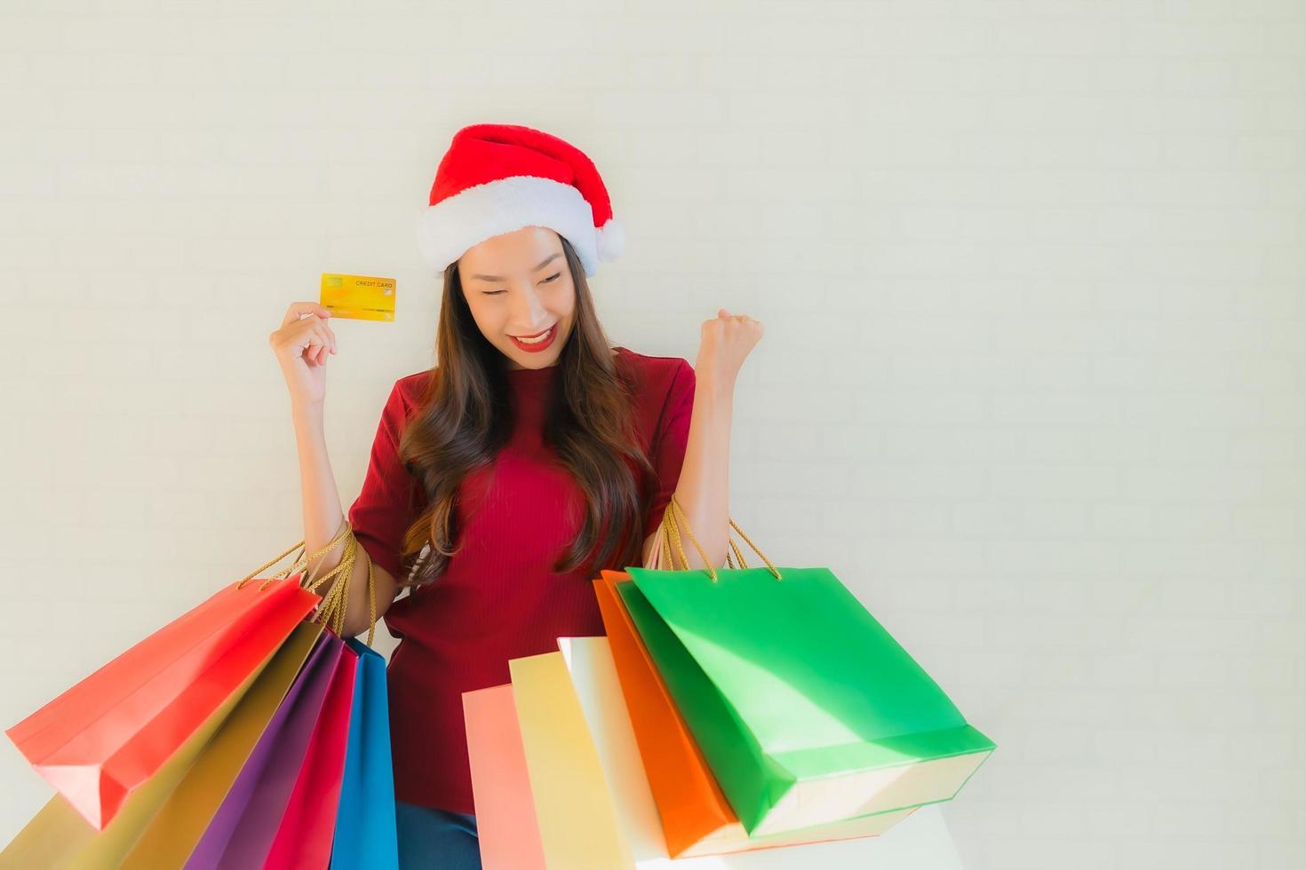 Retrato de hermosas mujeres asiáticas jóvenes usan gorro de Papá Noel de Navidad con bolsa foto