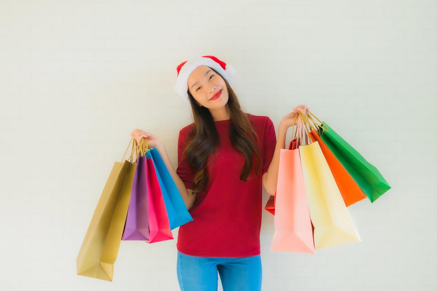 Retrato de hermosas mujeres asiáticas jóvenes usan gorro de Papá Noel de Navidad con bolsa foto