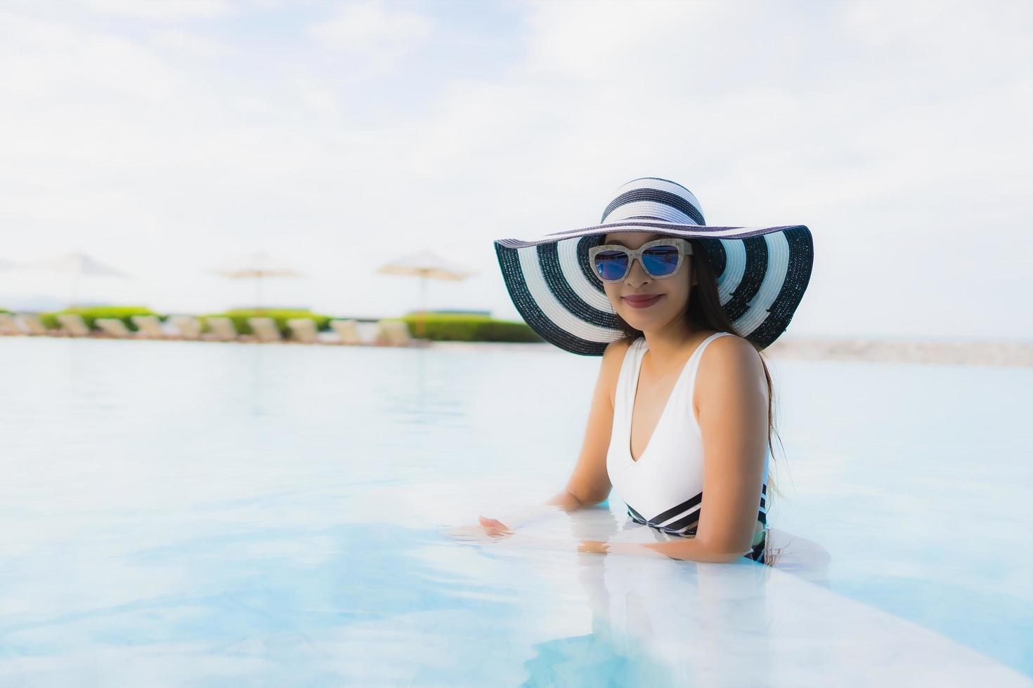 retrato, hermoso, joven, mujeres asiáticas, feliz, sonrisa, relajarse, alrededor, piscina foto