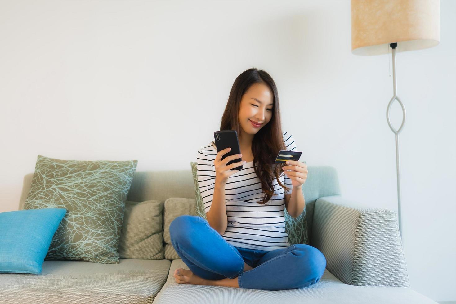 Retrato de hermosas mujeres asiáticas jóvenes con tarjeta de crédito, teléfono móvil o computadora para ir de compras foto