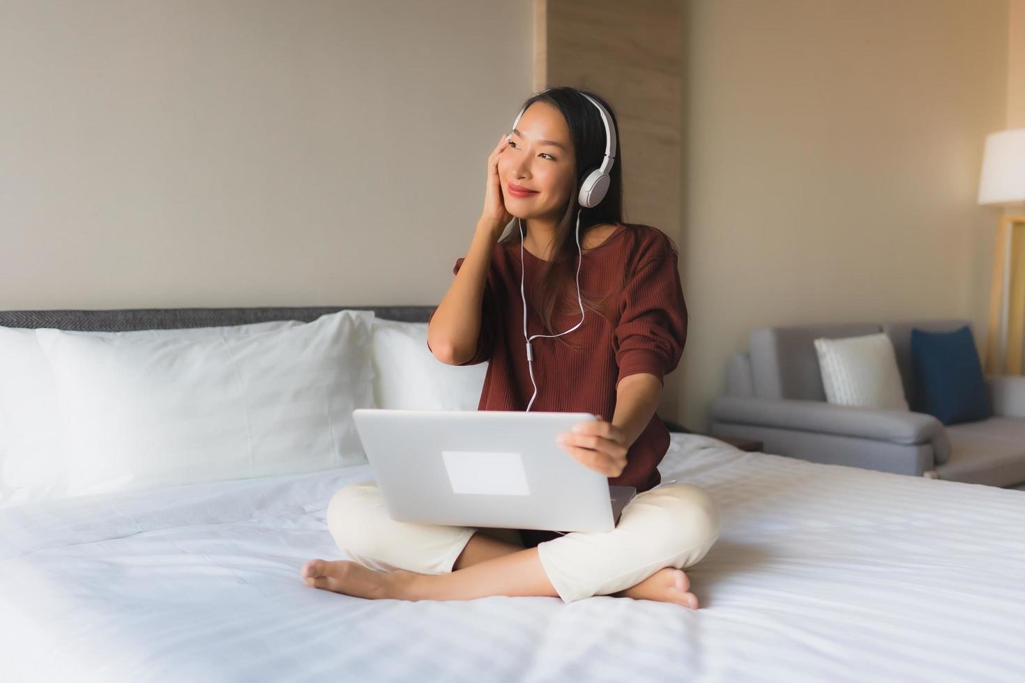 retrato, hermoso, joven, mujeres asiáticas, utilizar, computadora, y, auriculares, para, escuchar música foto
