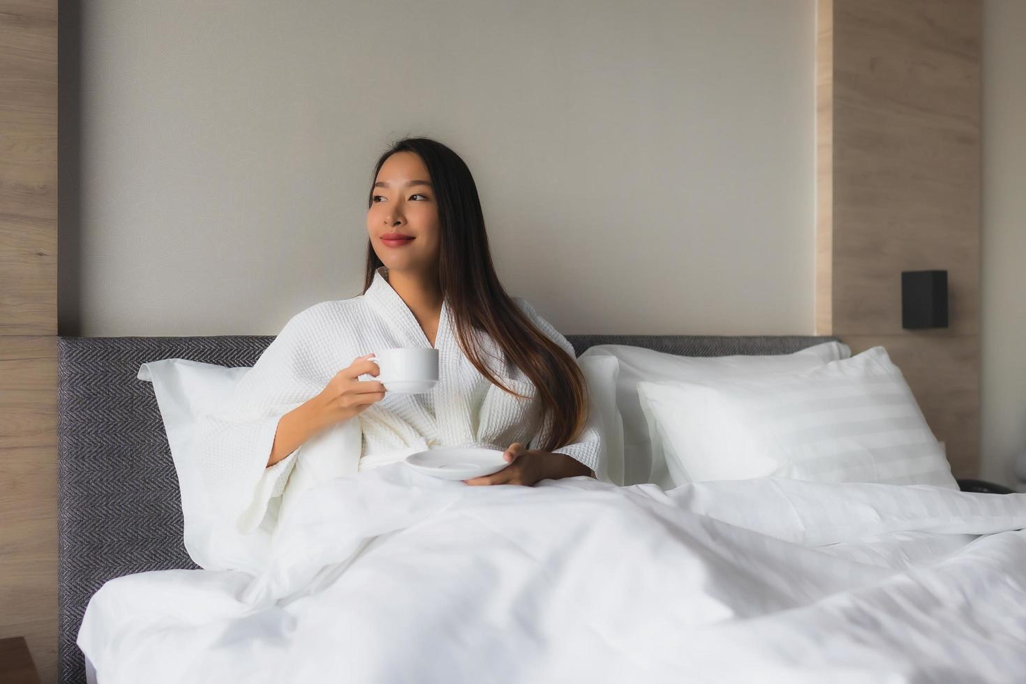 retrato, hermoso, joven, mujeres asiáticas, con, taza de café, en cama foto